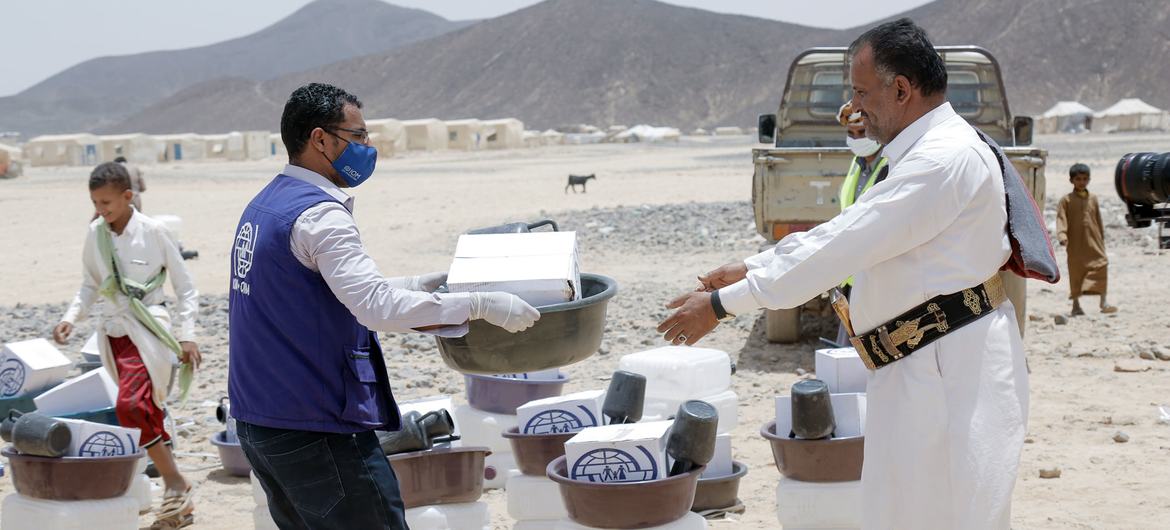 An IOM employee distributes relief kits to newly displaced communities in Ma'rib, Yemen.